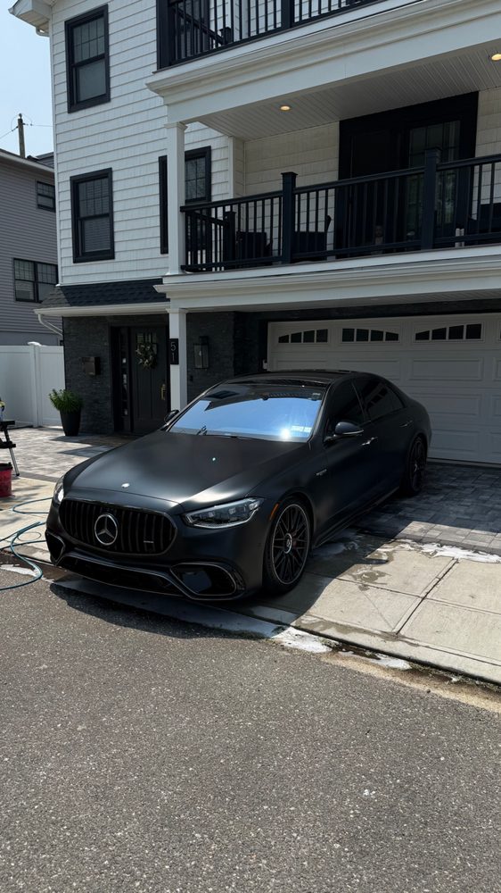 Black Mercedes-AMG sedan detailed in a driveway
