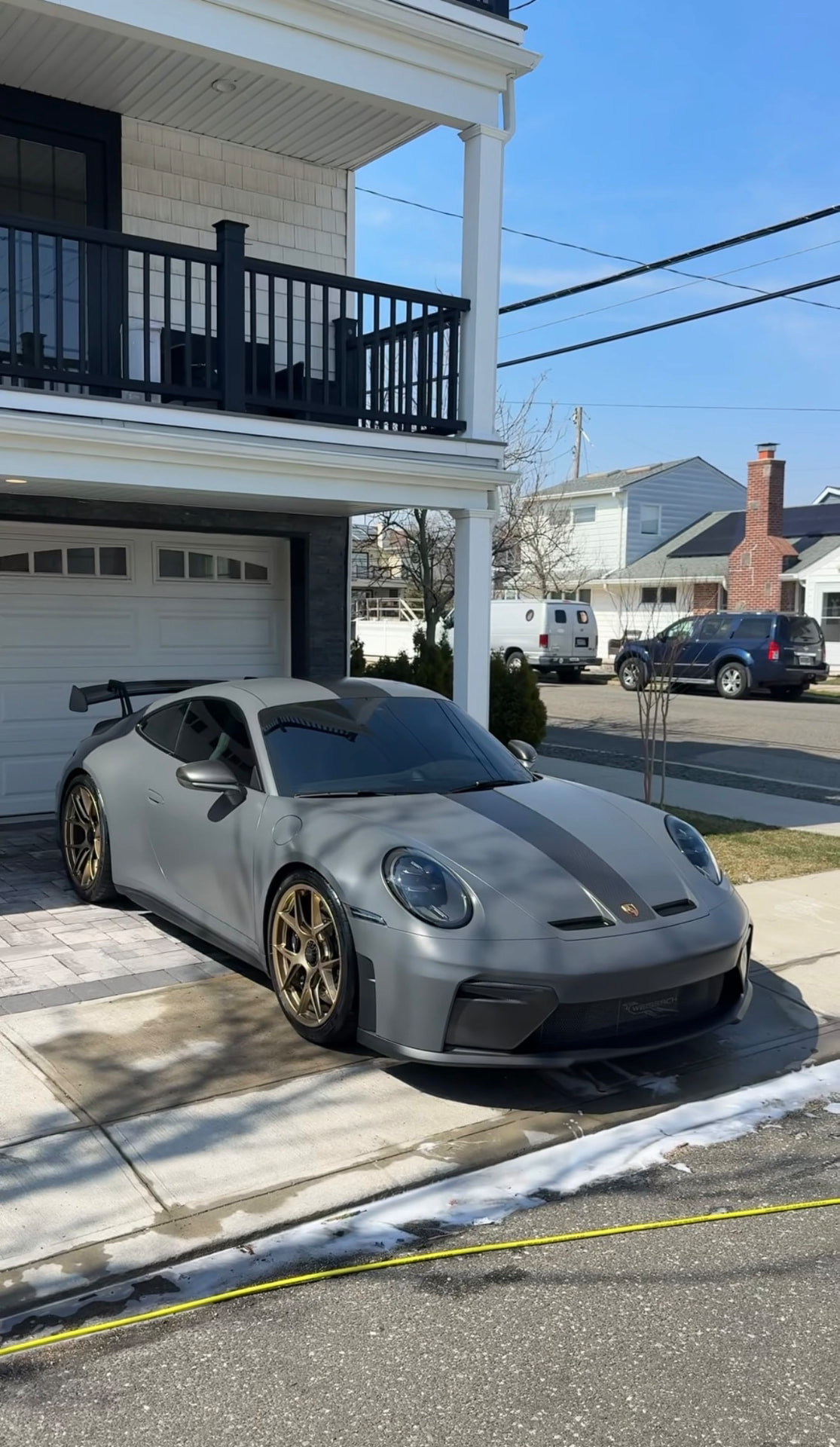 Grey Porsche 911 GT3 with gold wheels detailed in a driveway